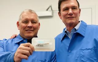 Spectrum's CEO and COO in background of photo with SDNA-1000 saliva DNA/RNA collection device