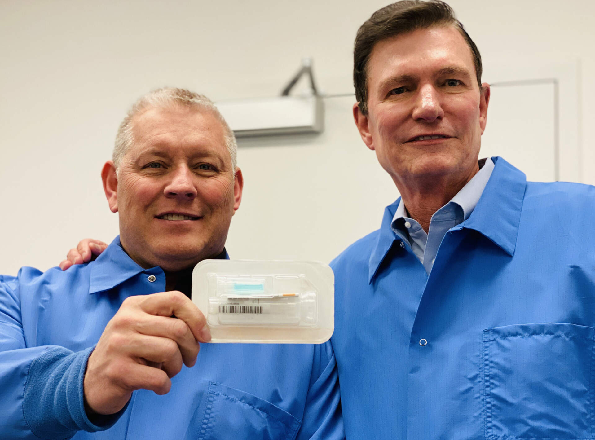 Spectrum's CEO and COO in background of photo with SDNA-1000 saliva DNA/RNA collection device
